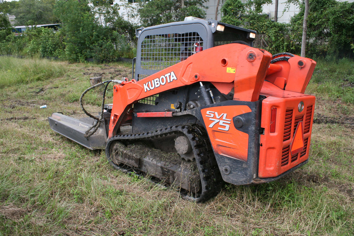 Kubota SVL 75 track loader working on a grassy erosion control site