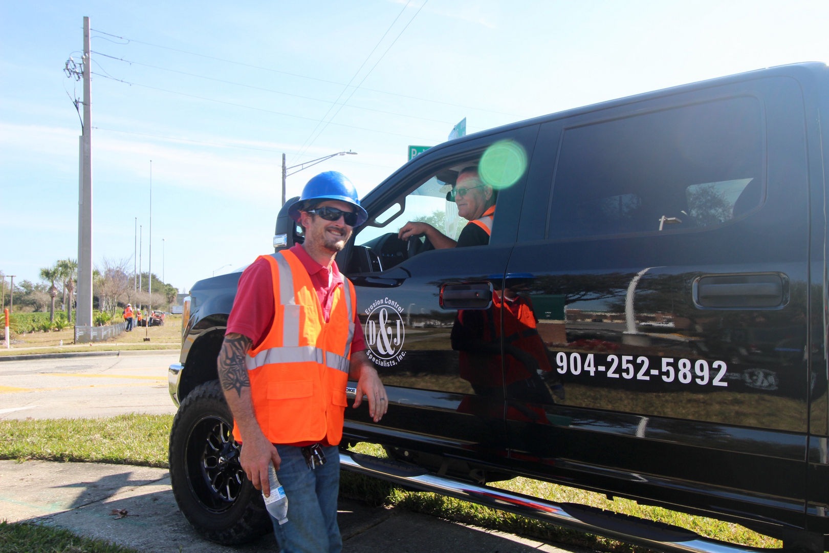 D & J Erosion Control Specialists team member beside a company truck