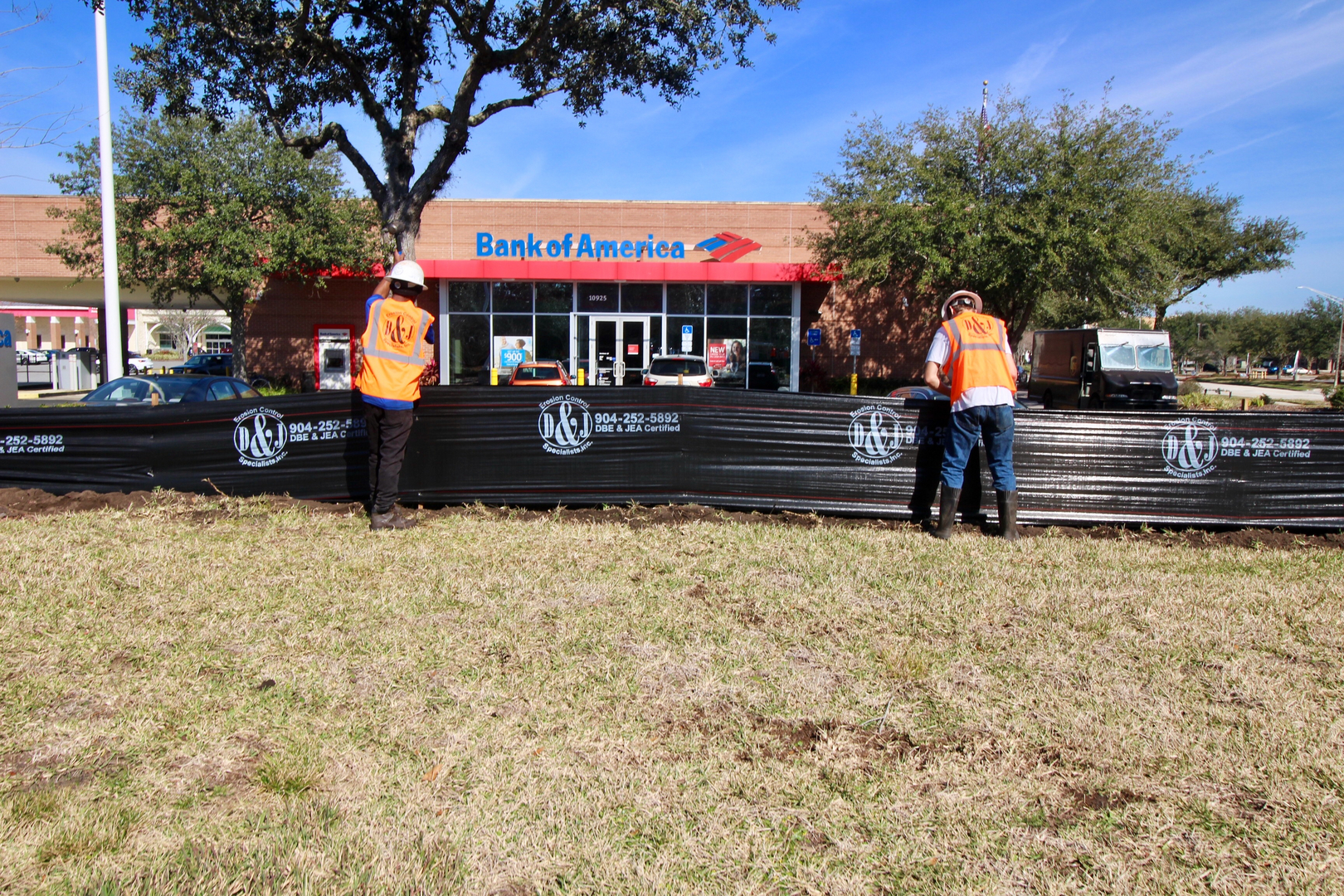 Workers installing a silt fence on a commercial site in Jacksonville